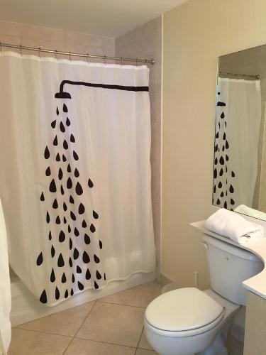 a bathroom with a toilet and a shower curtain at Miami Coral Gables Apartment in Miami