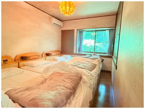 a room with three beds in it with a window at コテージちゃ豆ん家 in Nasu