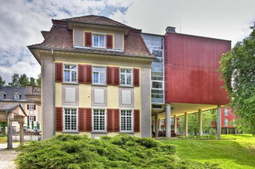 a large building with red shutters on it at Santé Royale Hotel- & Gesundheitsresort Bad Brambach in Bad Brambach