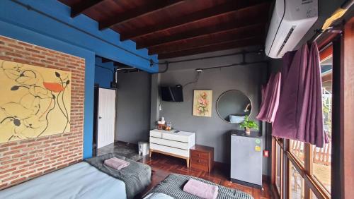 a bedroom with a blue accent wall and a bed at Bigcountry Tour Stay Ayutthaya in Phra Nakhon Si Ayutthaya