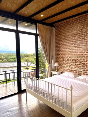 a bedroom with a bed and a brick wall at Chanti resort in Khao Kho