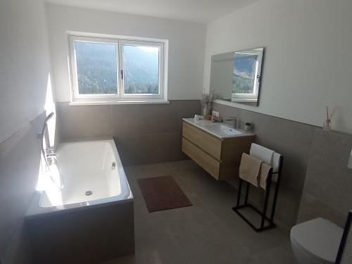a bathroom with a tub and a sink and a toilet at Panorama Wildgrat in Wenns