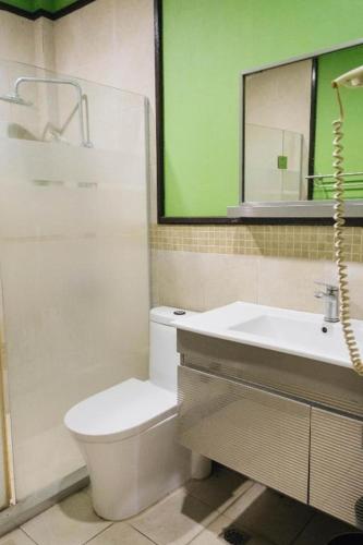 a bathroom with a toilet and a sink and a mirror at La Traviesa Hotel Resort in General Trias