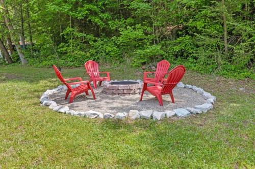 three red chairs sitting around a fire pit in the grass at WiFi - Dreamcatcher - Lux-Tiny Cabin in RRG KY in Rogers