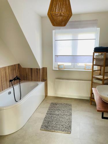 a bathroom with a bath tub and a window at Brockenblick in Blumenberg