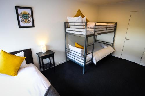 a room with two beds and a bunk bed at The Phat Palace in Otari