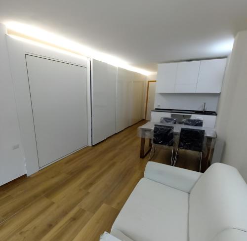 a living room with white cabinets and a white couch at Appartamento Viola in Santa Caterina Valfurva