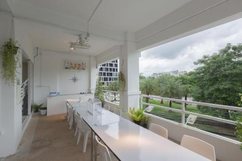 ein Zimmer mit weißen Tischen und Stühlen und einem großen Fenster in der Unterkunft HAO Hotel Phuket in Phuket