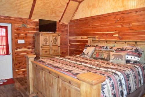 a bedroom with a bed in a log cabin at Secluded Getaway on a Vineyard in Allen, Oklahoma in Allen