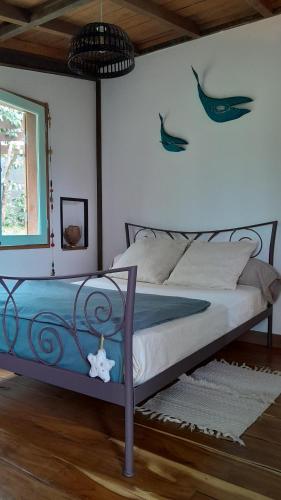 ein Schlafzimmer mit einem Bett mit einem Fisch an der Wand in der Unterkunft Ti Kaz Kafé - Charmante Case créole indépendante à St Leu in Saint-Leu