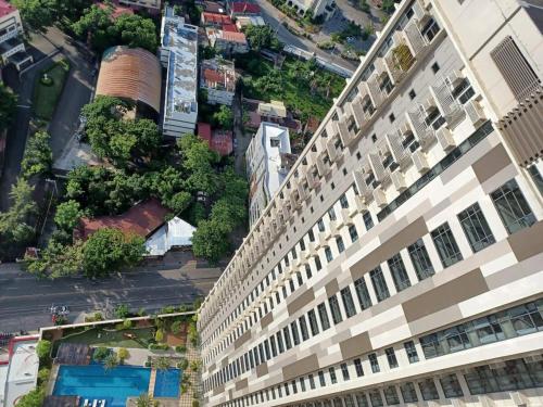 - une vue sur un grand bâtiment avec une piscine dans l'établissement 1bedroom suite 50th floor with balcony and bathtub at Horizons 101 tower 1, à Cebu