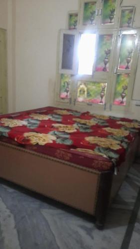 a bed sitting in a room with a window at Devaa Homstay in Mau