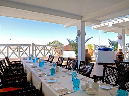 a long table with chairs and blue dishes on it at Atlas Essaouira Riad Resort in Essaouira