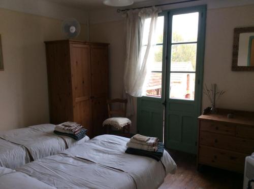 1 dormitorio con 2 camas individuales y ventana en Maison Lajus en Bassillon-Vauzé