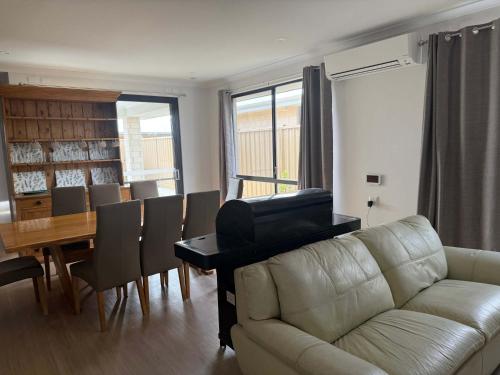 a living room with a couch and a piano at Milbridge Getaway with a bathroom in each room in Eaton