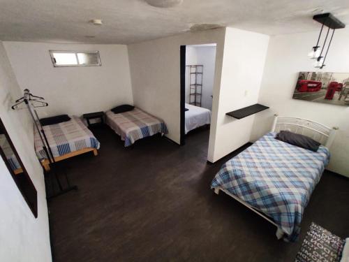 een kamer met 2 bedden en een spiegel bij Hotelito Ejido in Sanctórum