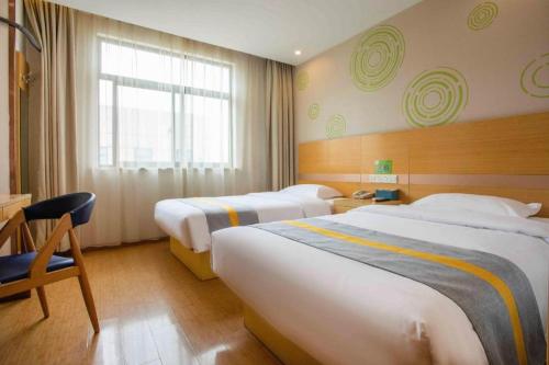 a hotel room with two beds and a chair at GreenTree Inn Shanghai National Convention and Exhibition Center Huaxiang Road in Shanghai