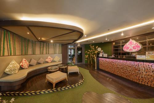 a hotel lobby with a couch and a bar at Aspira Petchkasem in Ban Khlong Om Noi