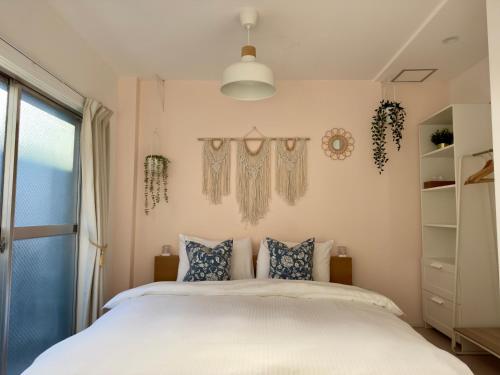 een slaapkamer met een wit bed en een raam bij Wi-fi4ac3tv55"30 in Osaka