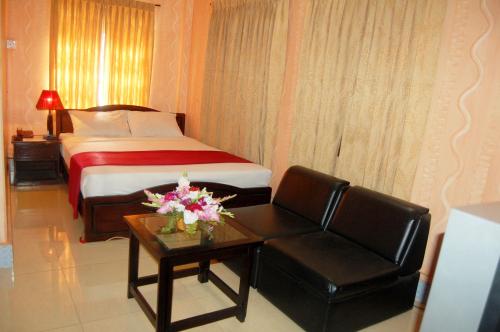 a hotel room with a bed and a chair and a table at Hotel Swiss Garden International in Chittagong