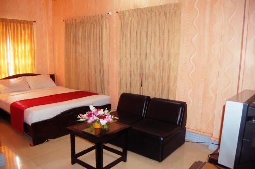 a hotel room with a bed and a couch and a television at Hotel Swiss Garden International in Chittagong
