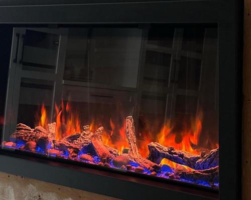 a fire in a fireplace with flames in it at Aqua Luxury House on the Shore in Laval