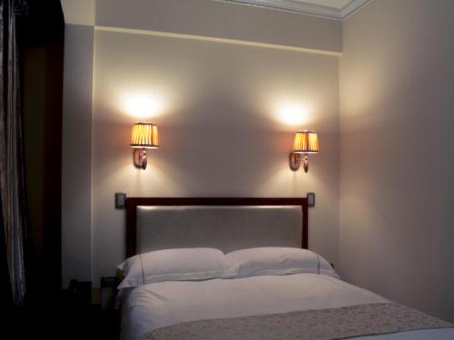 イキケにあるHotel Pekinのベッドルーム1室(壁に照明2つ付)