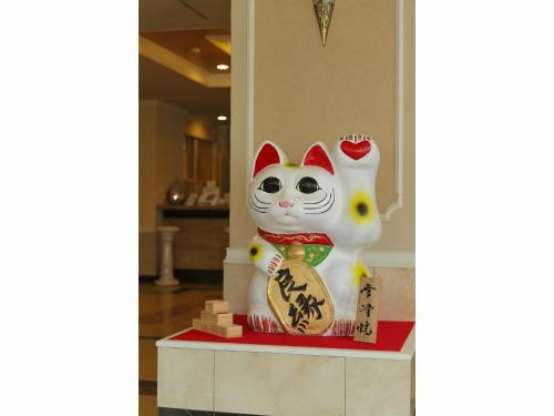 a statue of a cat sitting on a table at Spring Sunny Hotel Nagoya Tokoname ekimae in Tokoname