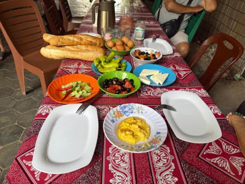 een tafel met borden met voedsel op een rode en witte tafeldoek bij Khmer rooms -Türk köyü - feridun abi nin yeri in Siem Reap