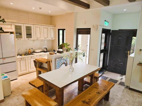 金湖鎮にある王老爺花園民宿のテーブルと椅子と冷蔵庫のあるキッチン