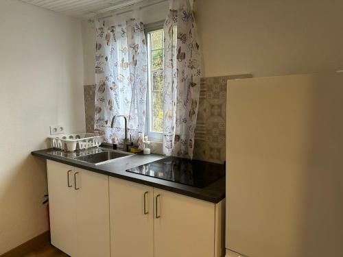 にあるCasa con parra de uva y pazのシンクと窓のあるキッチン