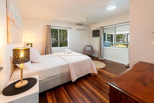 a bedroom with a bed and a desk and a window at Pet friendly beachfront home- sleeps 8 in Toogoom