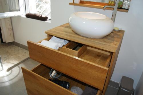 a bathroom with a bowl sink on a wooden shelf at Studio d'hôtes Villa Castelnau in Castelnau-le-Lez