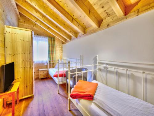 a bedroom with two bunk beds and a flat screen tv at Feriendorf Wildschönau Alpine comfort with family in Niederau
