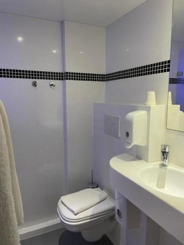 a white bathroom with a toilet and a sink at Brit Hotel Marvejols in Marvejols