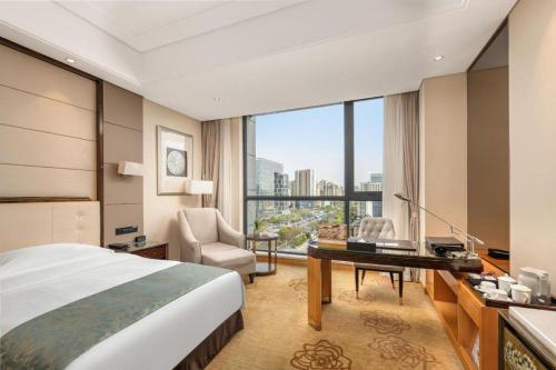 una habitación de hotel con una cama y un escritorio en Jin Jiang Mingcheng Hotel, en Yancheng