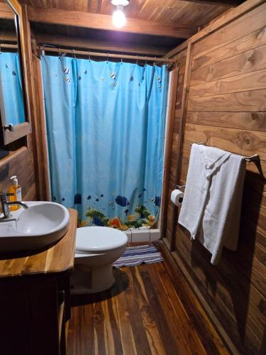 a bathroom with a fish shower and a sink at Hotel Cabañas La Teca in Liberia