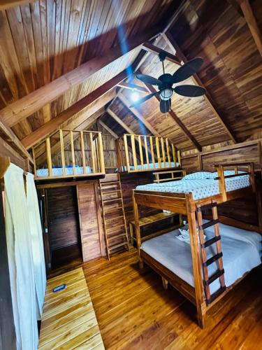 a room with two bunk beds and a ceiling at Hotel Cabañas La Teca in Liberia