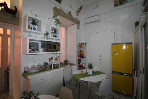 eine Küche mit einem gelben Kühlschrank und einem Tisch in der Unterkunft Le Vie Di Napoli B&B in Neapel
