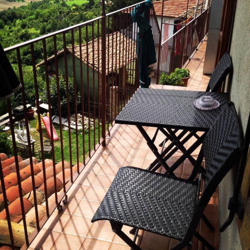 a black chair and a table on a balcony at B&B Monferrato La Casa Sui Tetti in Murisengo