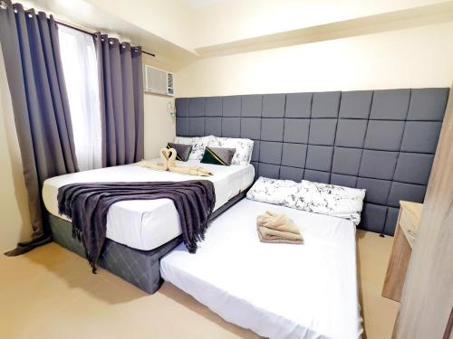 two beds in a room with blue walls at 1618T3 Avida Riala IT Park 1BR Unit in Cebu City