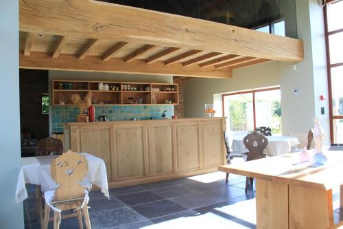 a kitchen with wooden cabinets and a table and chairs at B&B De Luyckhoek in Handzame