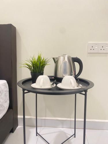 a table with a tea kettle and plates on it at AZ Roomstay Pendang in Pendang