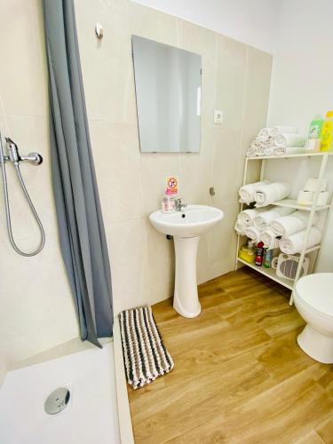 a bathroom with a sink and a toilet and a mirror at Villa Estrella in Dos Hermanas