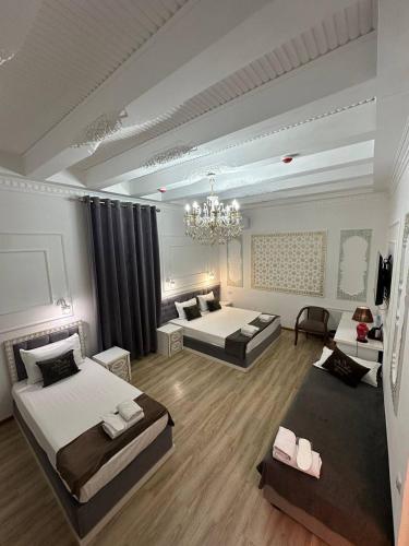 a large room with two beds and a chandelier at NABIBEK TERRACE Ponorama view old city in Bukhara