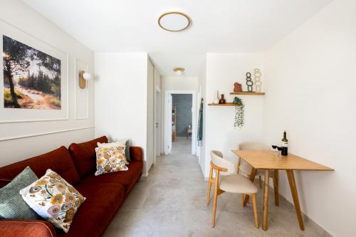 a living room with a couch and a table at ארץ-נגב צימרים בירוחם in Yeroẖam