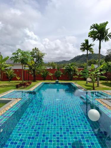 a pool at a resort with palm trees at Bungalow Khao Lak in Khao Lak