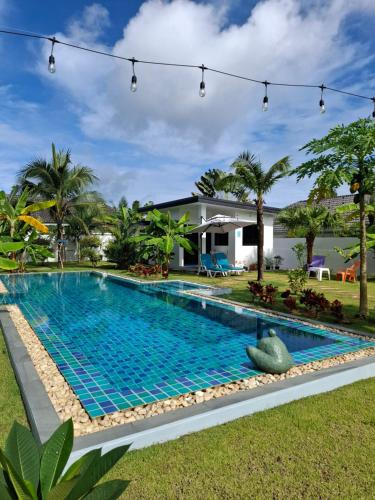 a swimming pool in front of a house at Bungalow Khao Lak in Khao Lak
