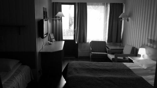 a hotel room with a bed and a television at Skånevik Fjordhotel in Skånevik