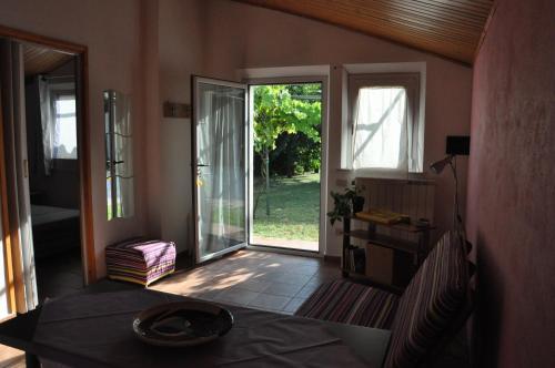 sala de estar con mesa y puerta corredera de cristal en La Vite sul Tetto, en Agugliano